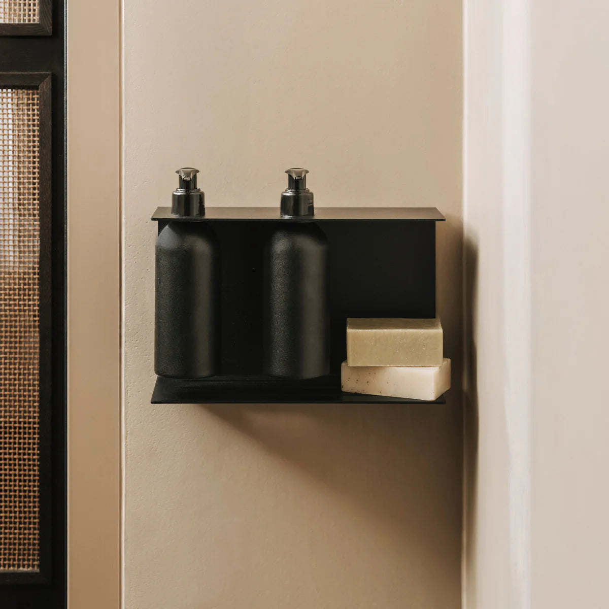 Dispensador de jabón de pared Catania en negro mate instalado en un baño