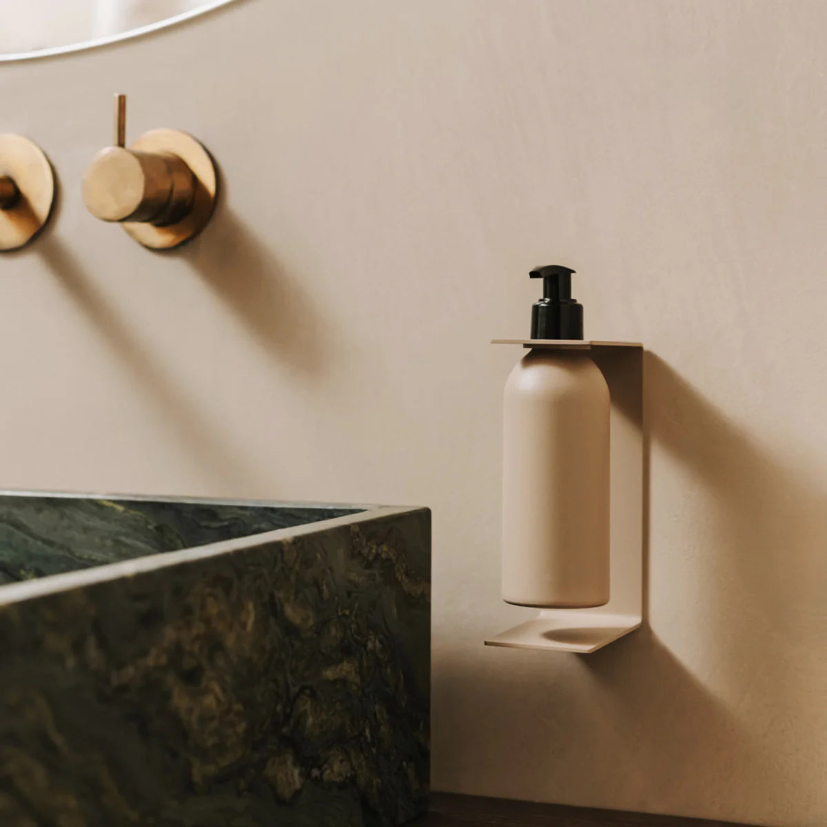 Dispensador de jabón de pared Catania en beige mate instalado en un baño minimalista