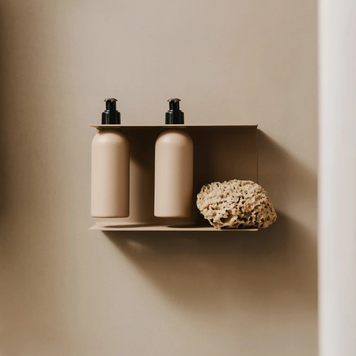 Dispensador de jabón de pared Catania en beige instalado en un baño minimalista